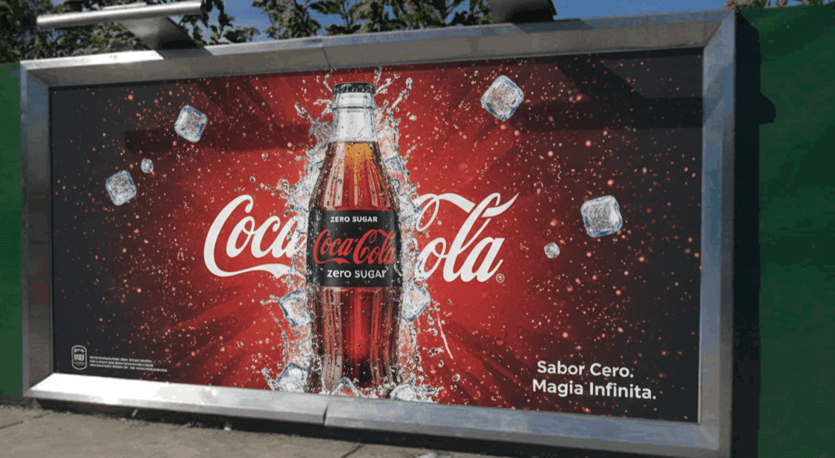 Valla fija publicitaria de Coca-Cola Zero con diseño rojo y hielo, instalada en vía pública.