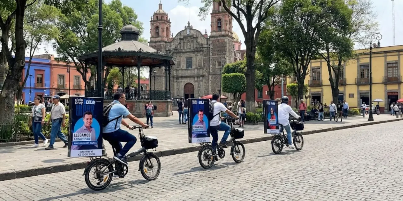 Bicivallas publicitarias en caravana con campaña institucional de la marca ULA en entorno urbano de alto valor cultural