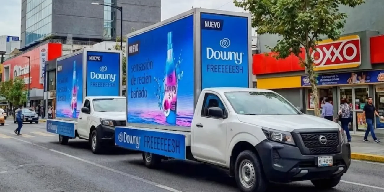 Vallas móviles con publicidad de la marca Downy montadas en camionetas para campaña de lanzamiento de producto